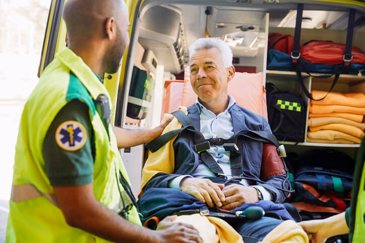 EMT comforts man about to be transported by ambulance