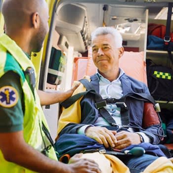 EMT comforts man about to be transported by ambulance