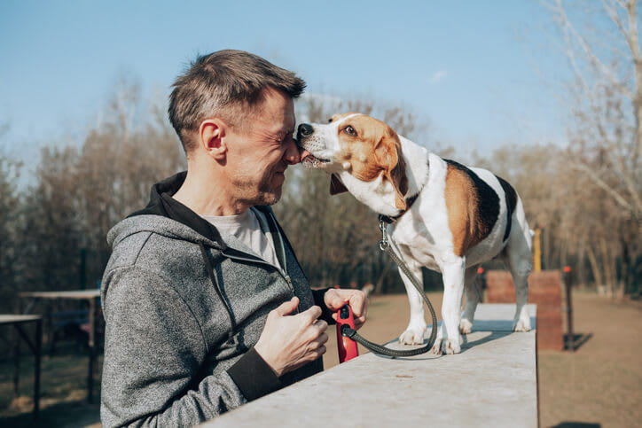 Dog licks owner on the face