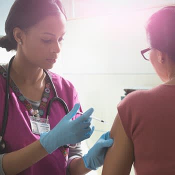 Nurse gives medication shot to patient