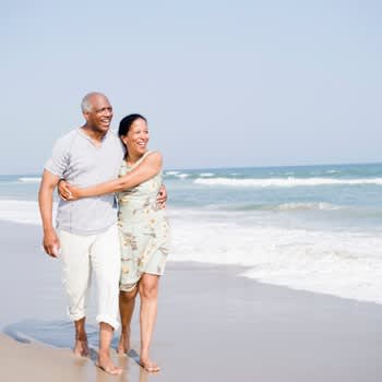 Couple embracing as they walk along the beach