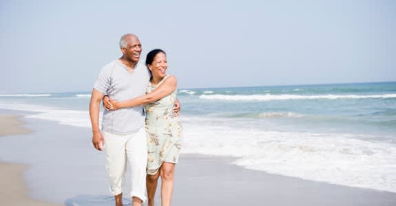 Couple embracing as they walk along the beach