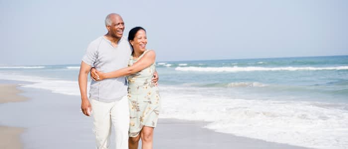 Couple embracing as they walk along the beach