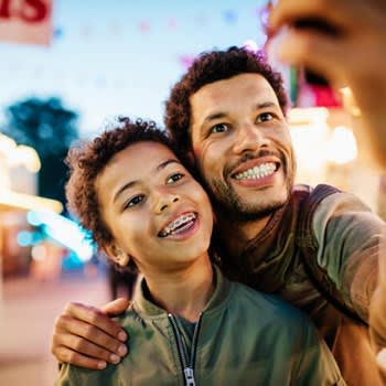 Father takes selfie with his son who has braces