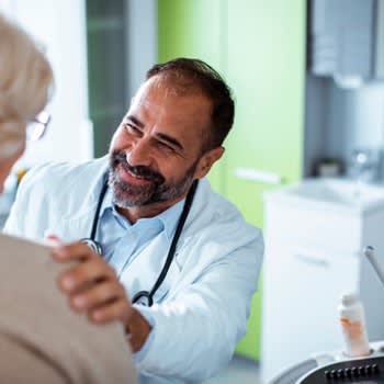 Doctor smiles and talks with patient