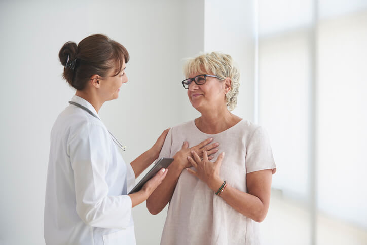 Woman expresses relief while speaking with comforting doctor