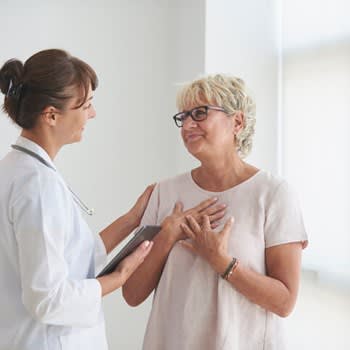 Woman expresses relief while speaking with comforting doctor