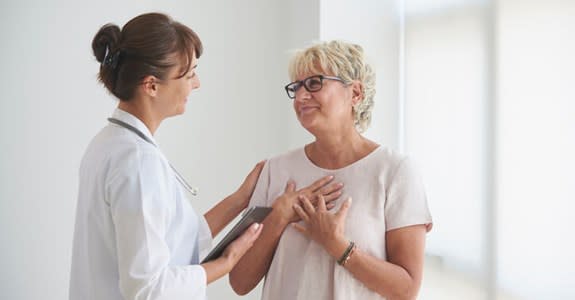 Woman expresses relief while speaking with comforting doctor