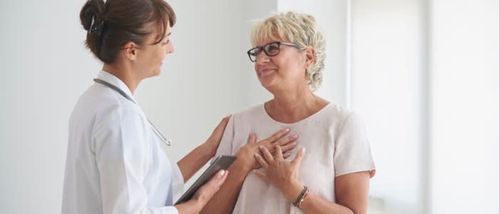 Woman expresses relief while speaking with comforting doctor