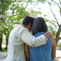 Rear view of two women comforting each other with embrace