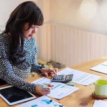 Woman using calculator to determine costs