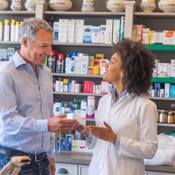 Smiling pharmacist helping customer at pharmacy