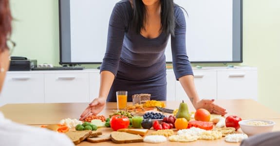 Nutritionist dietitian lays out healthy foods on table for clients