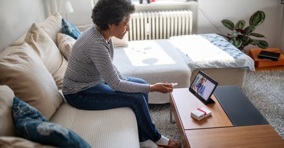Woman at home speaks with doctor using telemedicine
