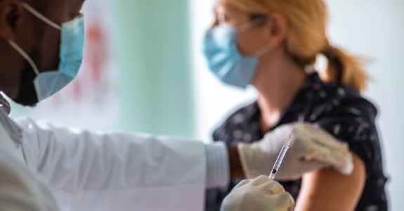 Doctor administers flu shot vaccination to patient