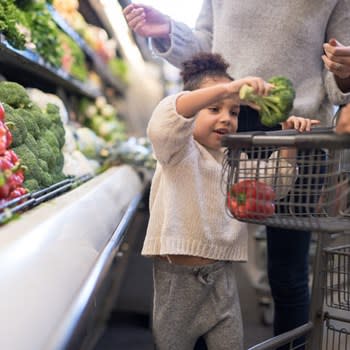 Girl Puts Produce In Grocery Cart