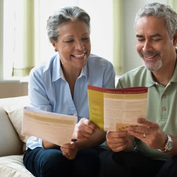 Smiling couple at home reviewing insurance information