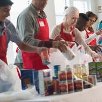 Volunteer workers pack food into bags to distribute