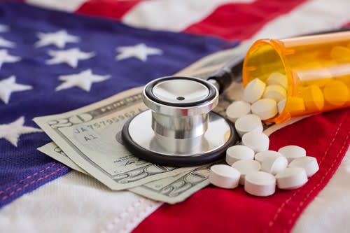 American flag with money and medicine and a stethoscope