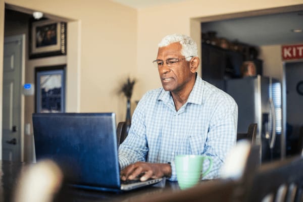 Man types on his laptop computer at home