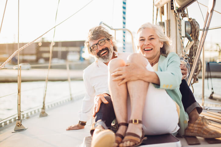 Smiling couple on a sailboat on a sunny day