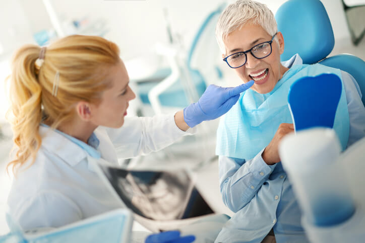 Dentist shows her patient results of dental Xrays