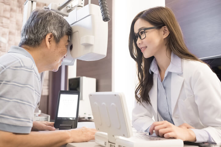 Eye doctor gives eye exam to her patient
