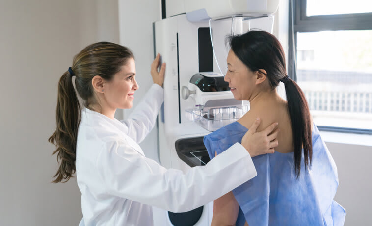 A doctor gives her patient a mammogram