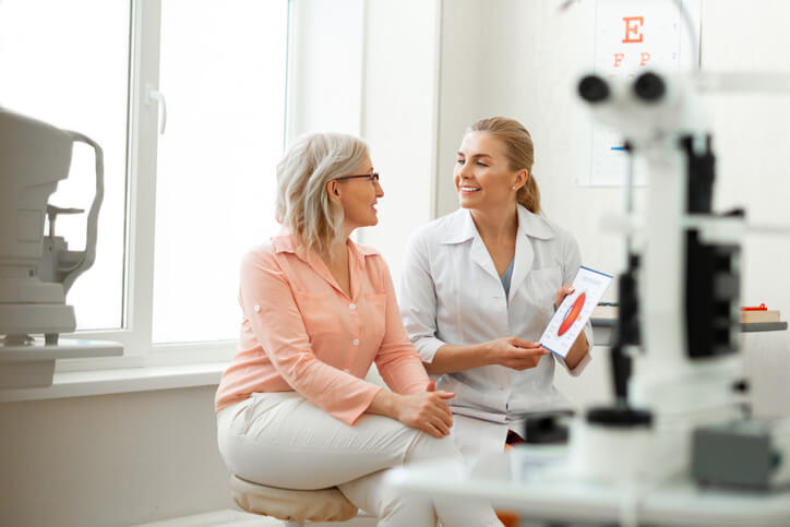 Eye doctor talks with her patient in her office