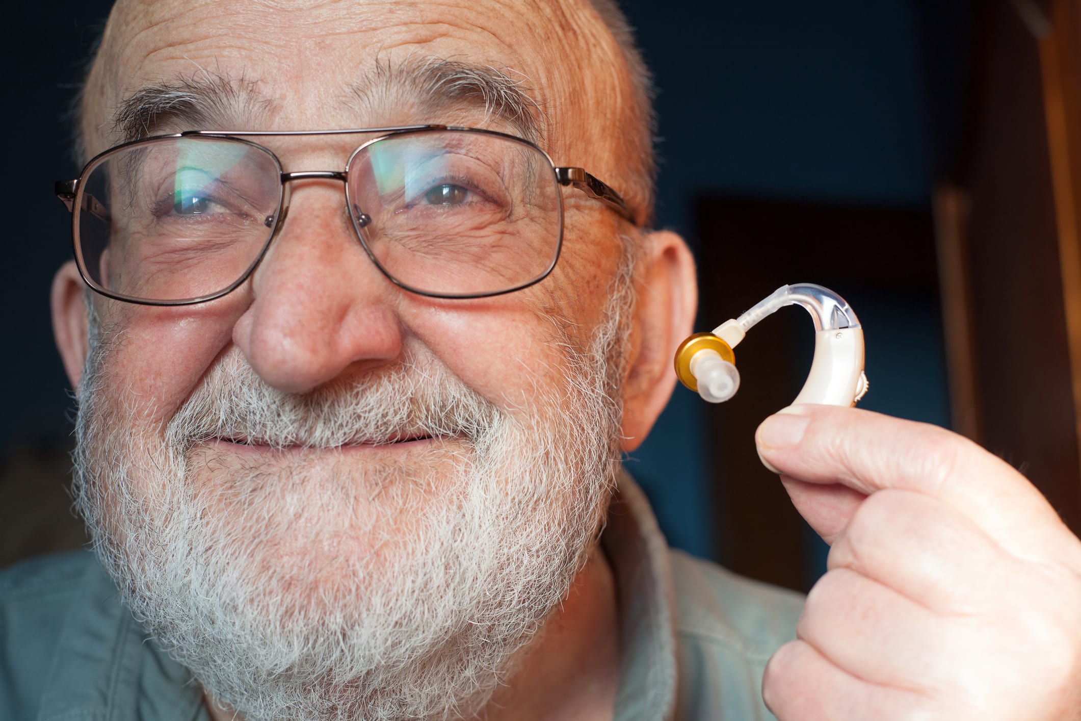 Senior Man Holding Hearing Aid