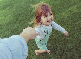 Happy young girl plays with parent