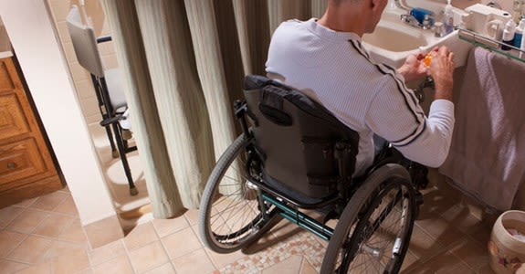 Man uses wheelchair in bathroom remodeled for accessibility