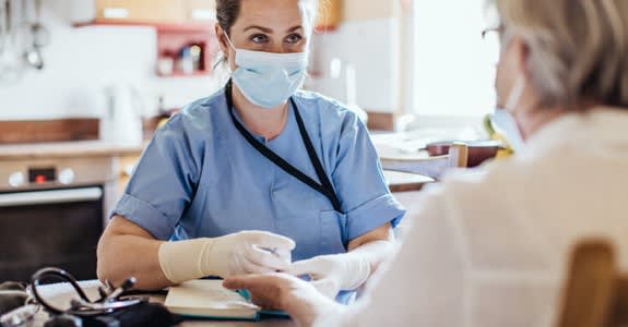Nurse wearing a mask takes blood for patient