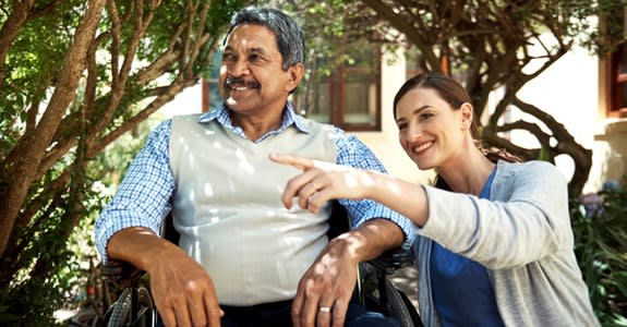 Caregiver points to something while spending time outside with patient