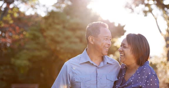 Smiling couple outdoors with sun in the background