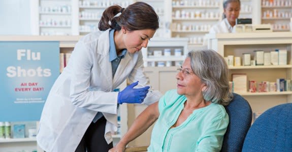 Pharmacist gives flu shot in the pharmacy