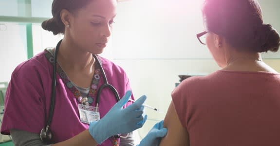 Nurse gives medication shot to patient