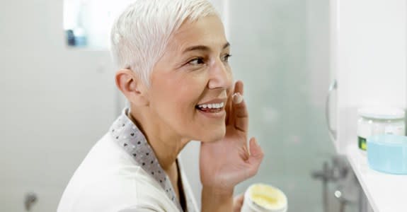 Woman applies acne cream