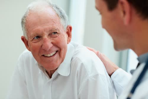 Man smiles as he talks with his doctor