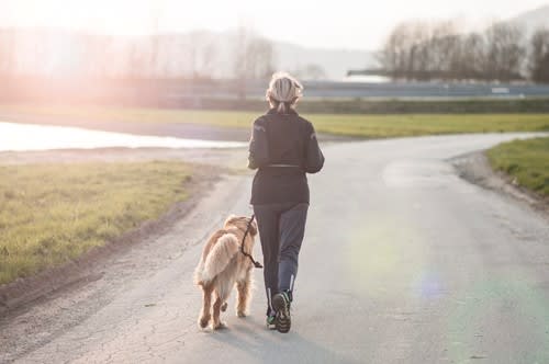 Woman walks outside with her dog