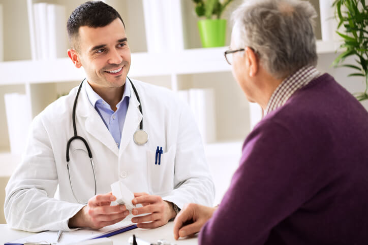 Doctor smiles as he speaks with his patient
