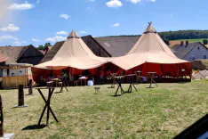 Zweiertipi auf einer Wiese mit Tischen im Vordergrund