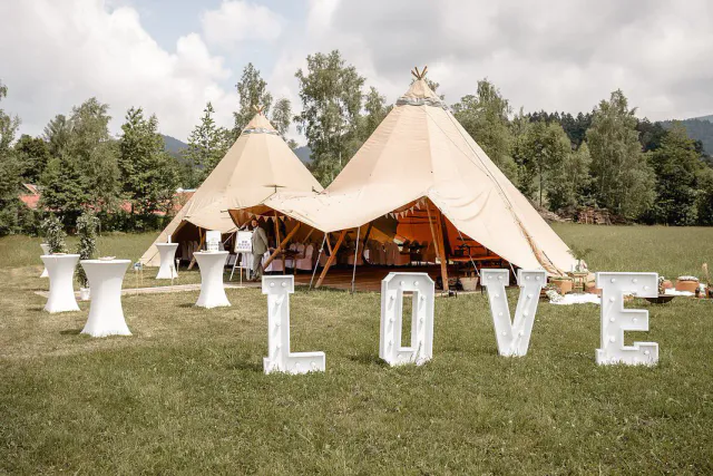 Hochzeitstipi mit Buchstaben Love vor dem offenen Eingang