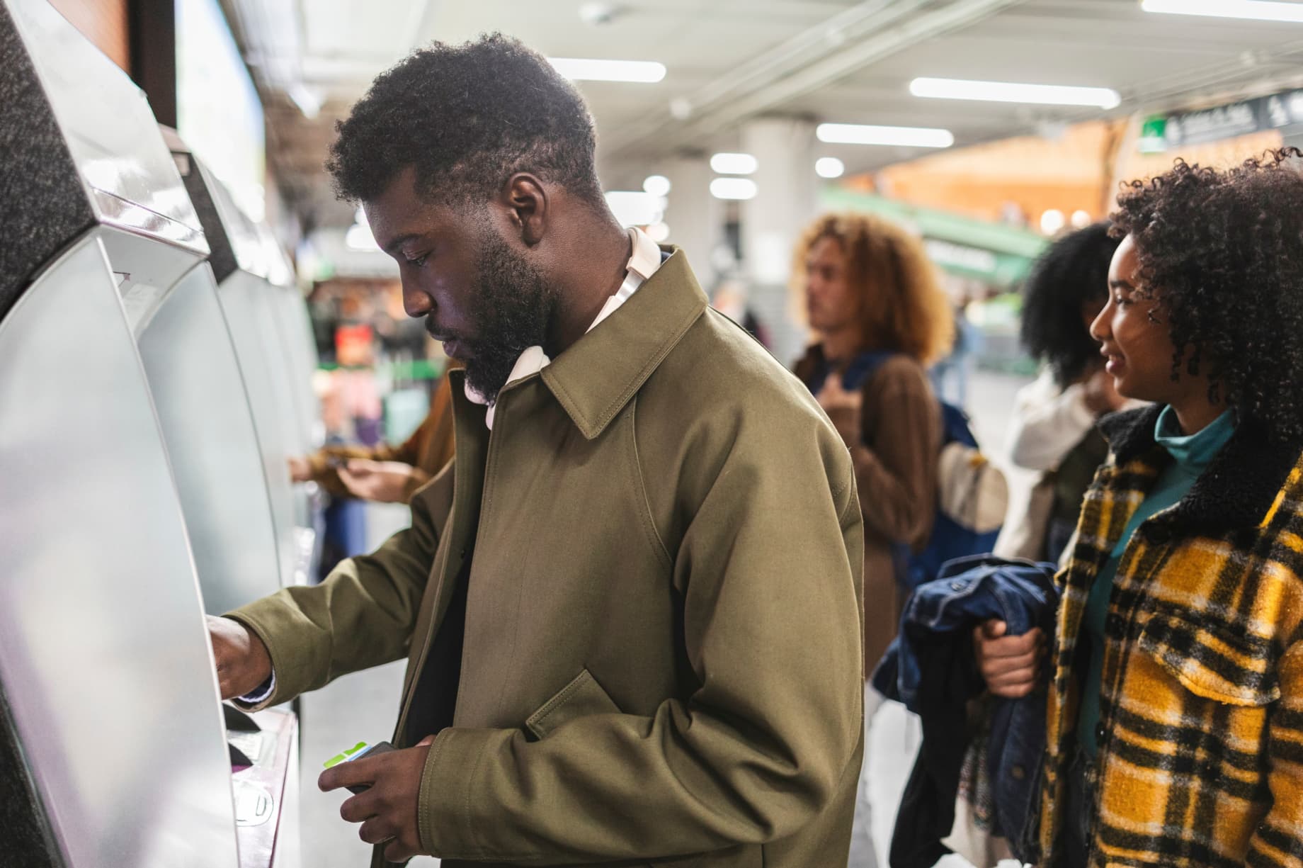 Dissatisfied young traveller exchanging money at the airport using airport atm - 7 INTERNATIONAL TRAVEL FACTS: A Simple Guide to a Smooth Trip - International Travel Tips - Travel facts