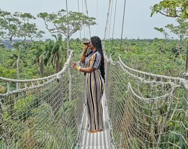 Woman standing on Lekki Conservation Center Canopy Walkway and using her telescope to view the entire surroundings - Lekki Conservation Center Reviews