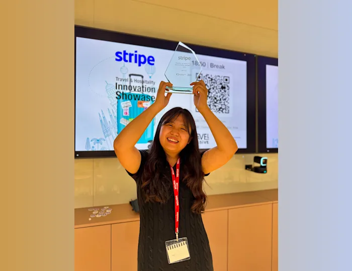 A winner of the startup competition holding a glass trophy above their head and smiling