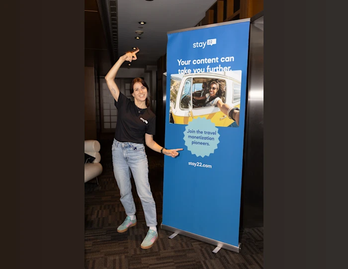 Maria Stoyanova from Stay22 in front of a Stay22 roll up banner