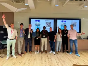 A group of nine attendees at the front of the stage showing excitement for the camera.