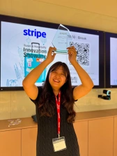 A winner of the startup competition holding a glass trophy above their head and smiling
