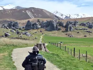 A person in a wheelchair going down a path in the hills